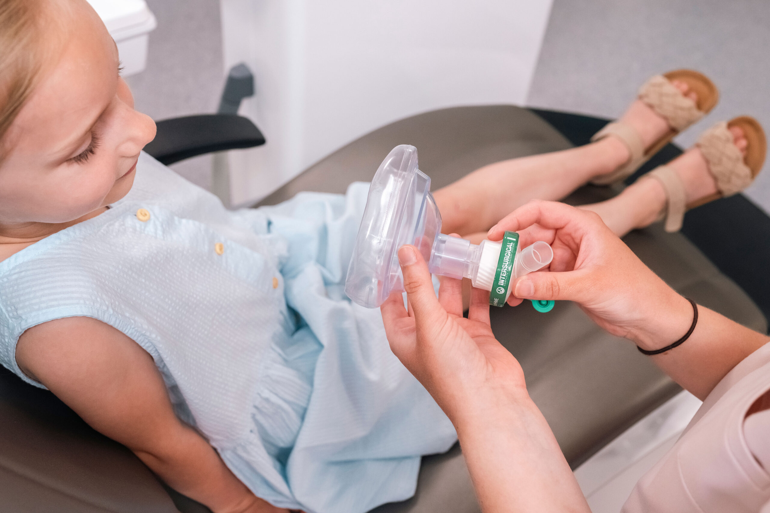 Child being prepared for treatment with a calming mask in a dental clinic
