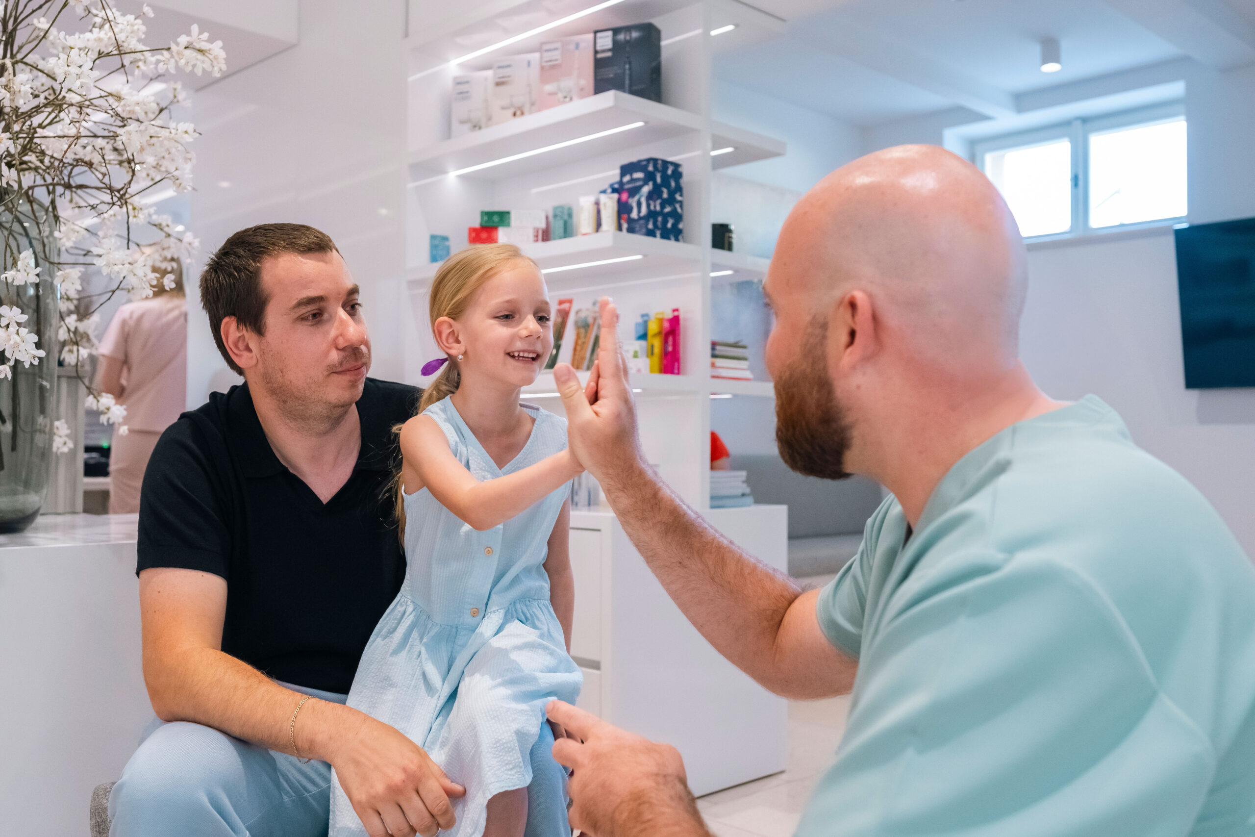 Dentist communicating with a child and parent during a consultation