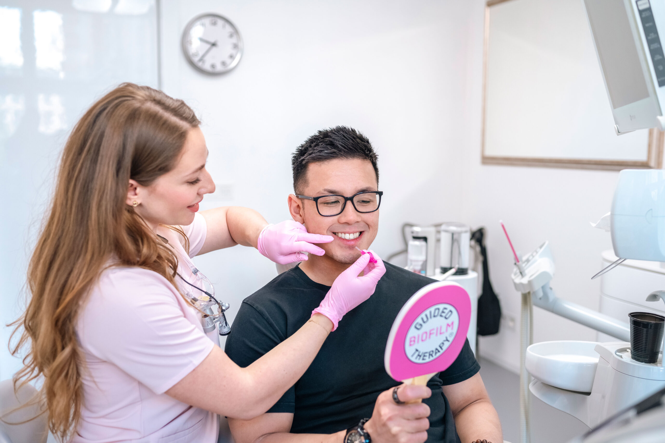 Dentální hygienistka vysvětluje mezizubní čištění pacientovi