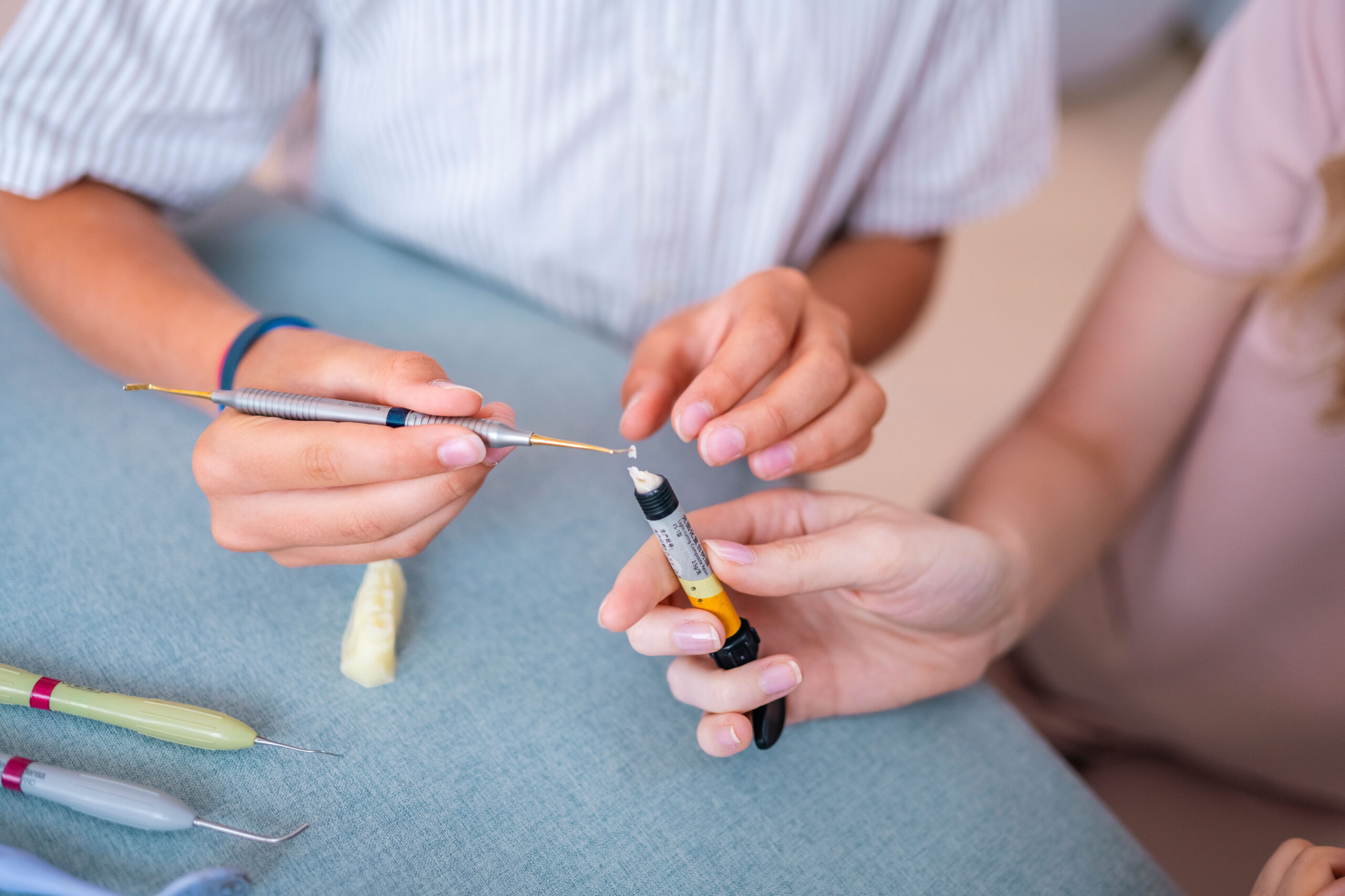 Dental professional showing composite filling material to a patient
