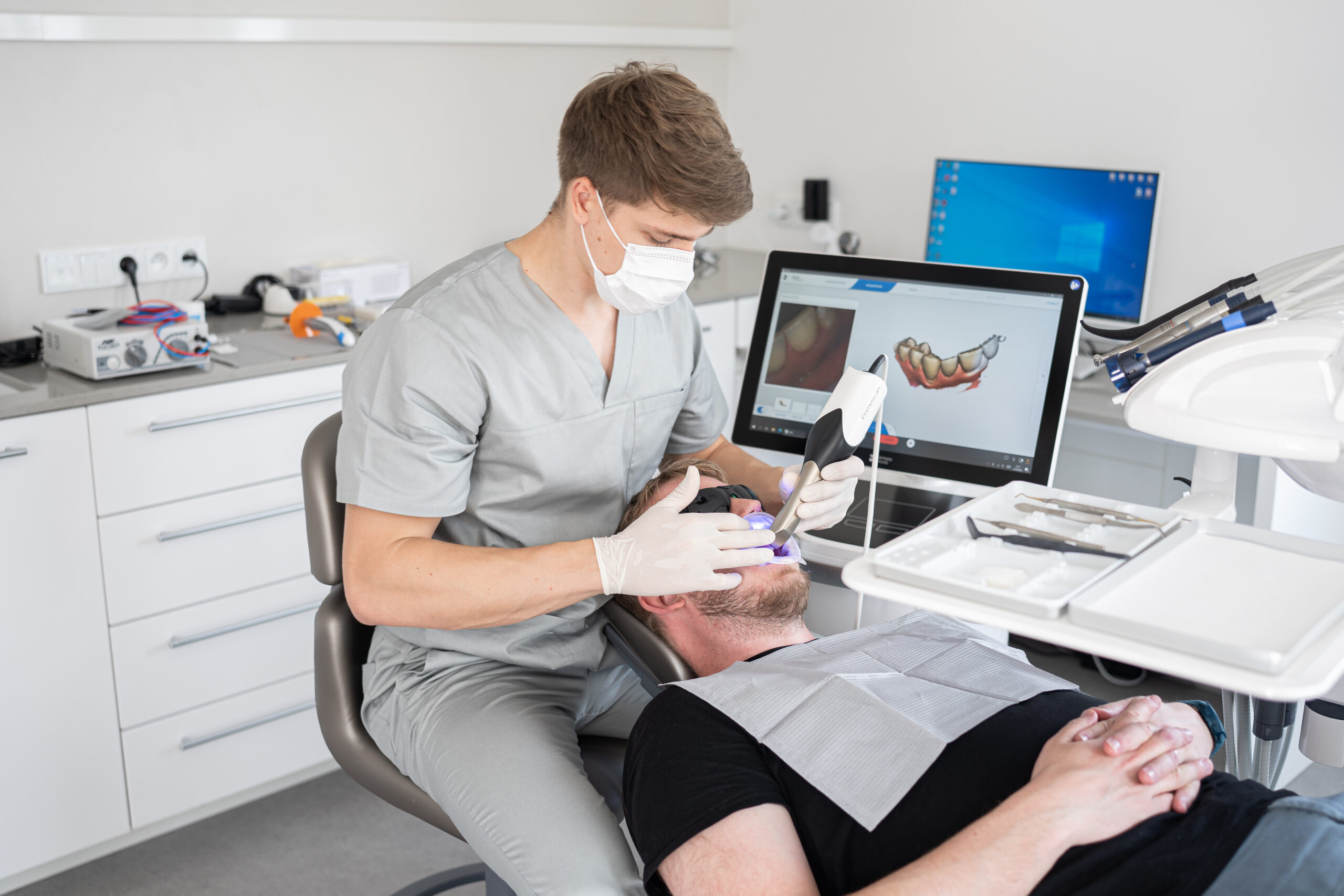 Dentist performing a digital dental scan of a patient in a modern dental clinic